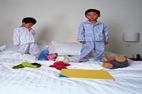 2 kids on bed standing