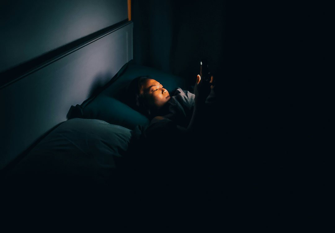 woman-lying-down-with-her-phone-can-not-sleep-by-tim-durgan-at-unsplash