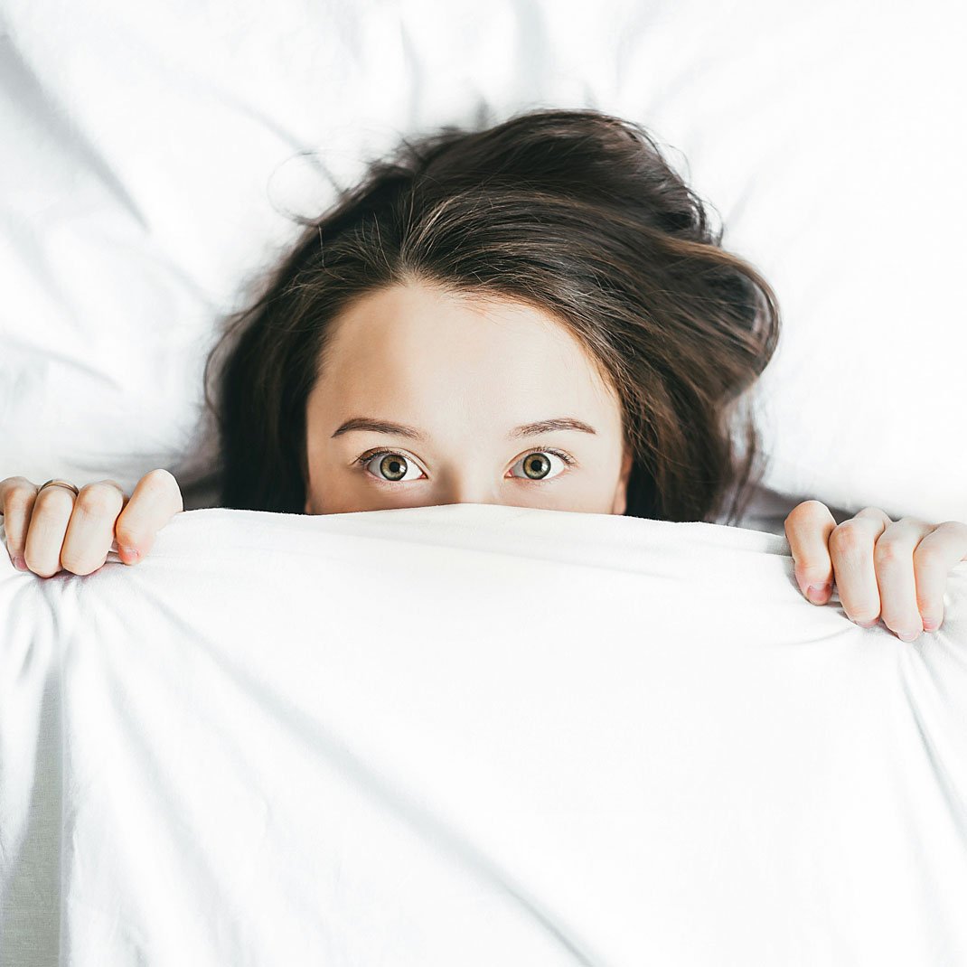 woman-wakes-up-half-covered-her-face-with-white-blanket-by-alexandra-gorn-at-unsplash