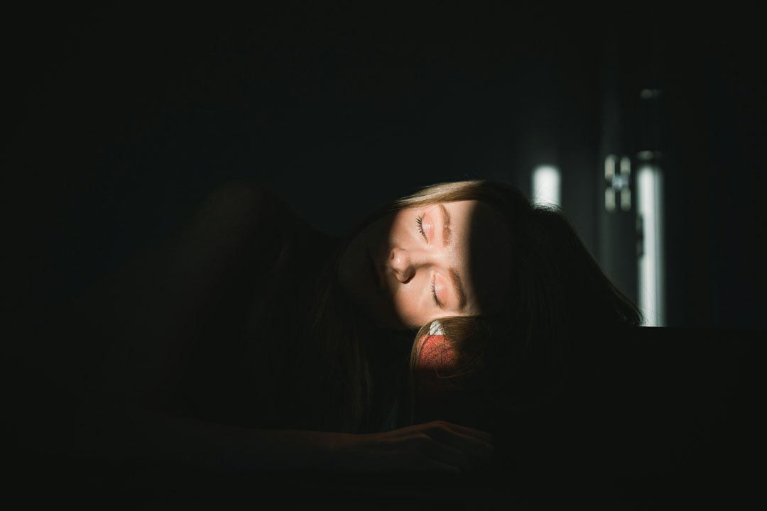woman-sleeping-with-lights-on-face-by-andrey-svistunov-at-unsplash