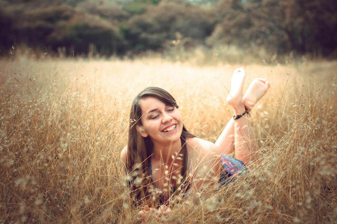 fulfilled-woman-on-high-grasses-paola-aguilar-unsplash